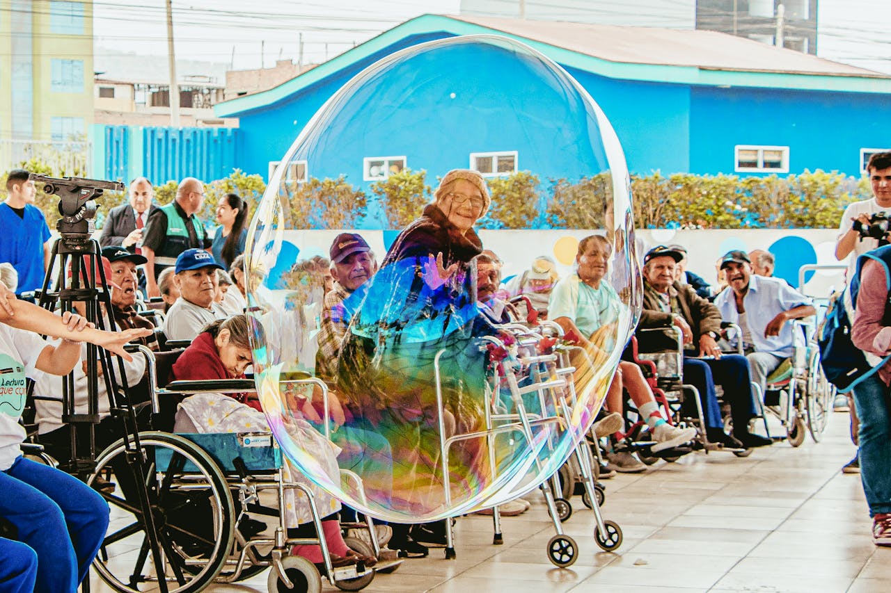 Elderly people enjoying a fun moment with a giant bubble outdoors in Lima, Peru.